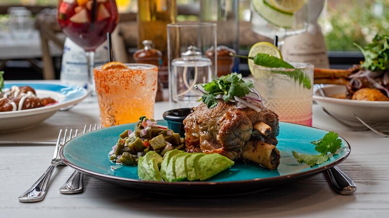 Pork shank entree with side of avocado and pineapple salad